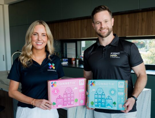 Brea Brand and Luke Daniher holding CONNETIX Charity Packs